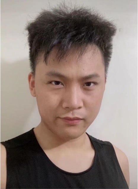A young man with spiked hair and a black tank top.